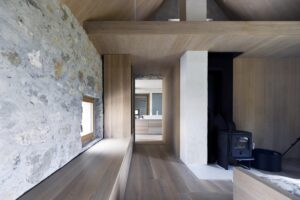Interiéru dominuje dřevo, které vytváří teplý kontrast ke starým stěnám.