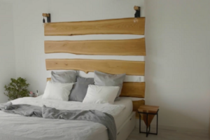 Dominantním prvkem je manželská postel s krásným dřevěným obkladem nad ní.