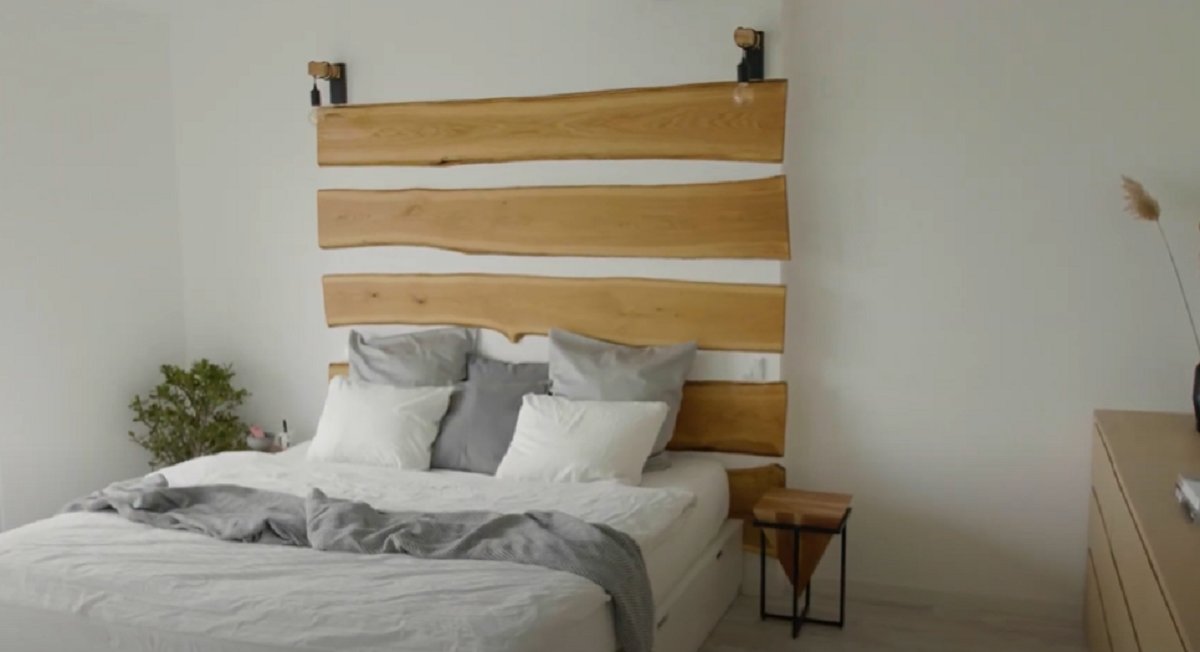 Dominantním prvkem je manželská postel s krásným dřevěným obkladem nad ní.