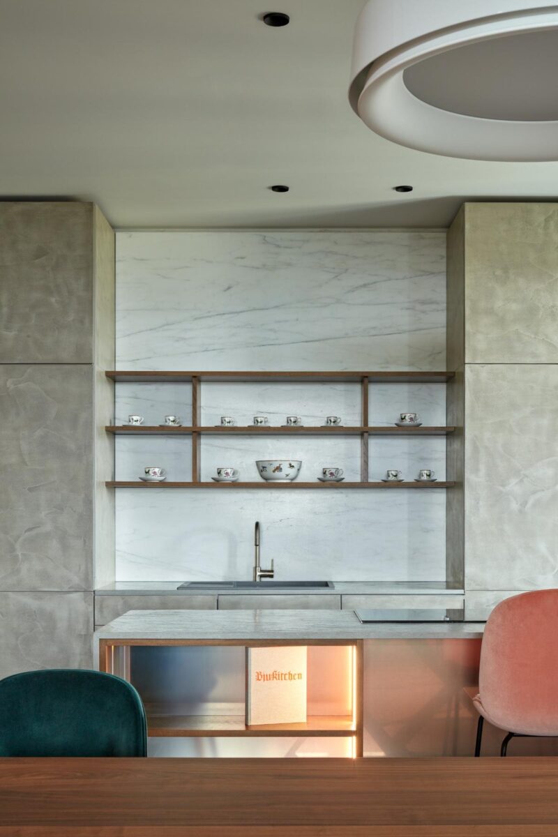 Kuchyňský kout je zařízen v minimalistickém stylu s důrazem na funkčnost a estetiku.