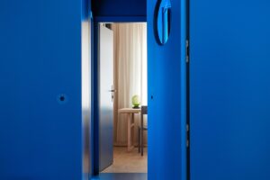 Moderní modré dveře vedoucí do světlé místnosti