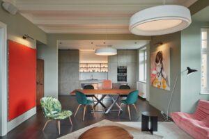 Šedé a zelenkavé odstíny stěn působí jako dokonalé pozadí pro barevné výkřiky nábytku.