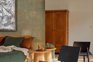 Ložnice s dřevěným nábytkem, zeleným povlečením a moderními dekoracemi na stěnách.