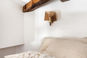 Ložnice s dřevěným trámem na stropě