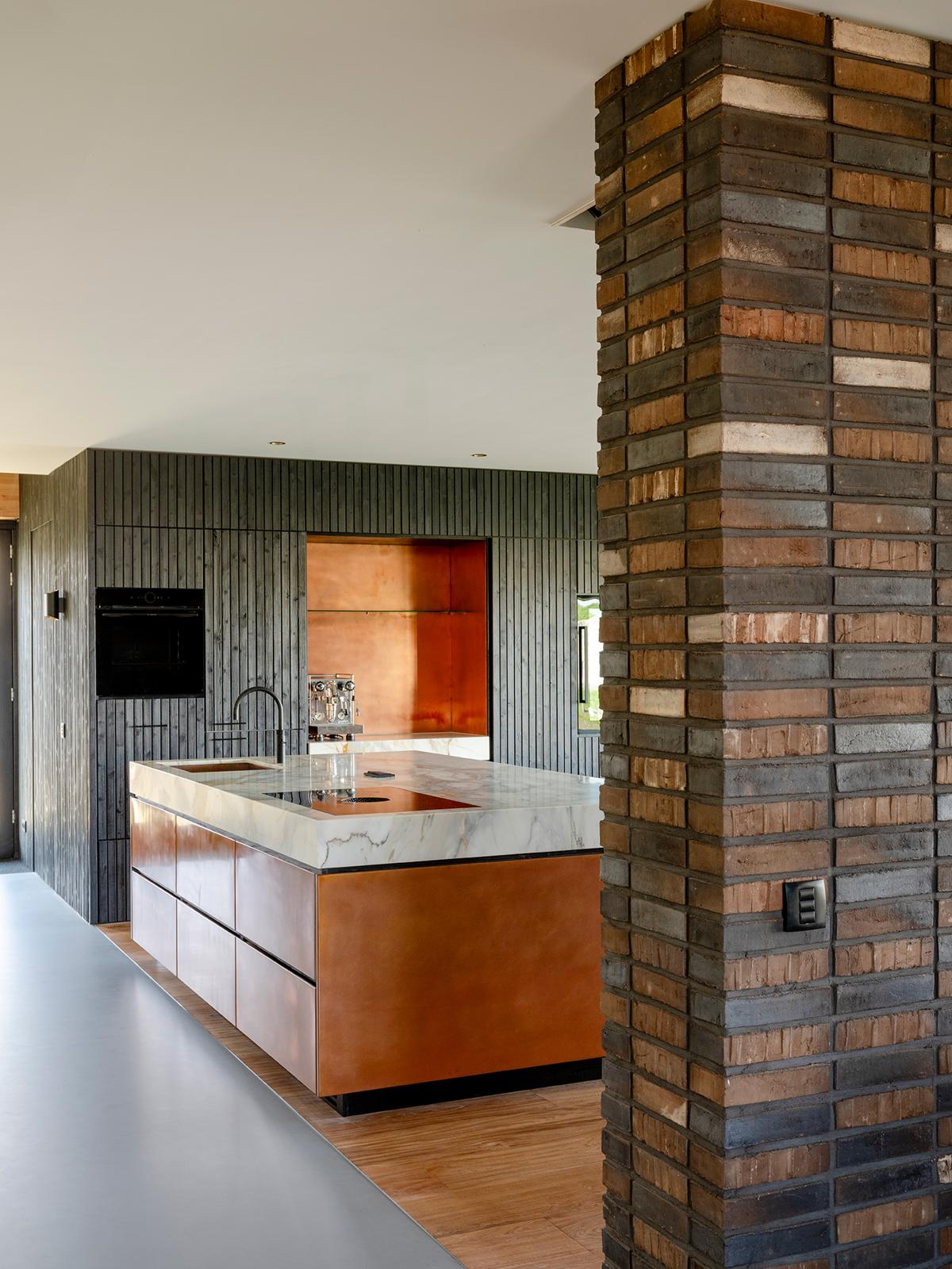Tato moderní kuchyně se vyznačuje výrazným mramorovým ostrůvkem a teplými dřevěnými skříněmi, což spojuje luxus s přírodními materiály.