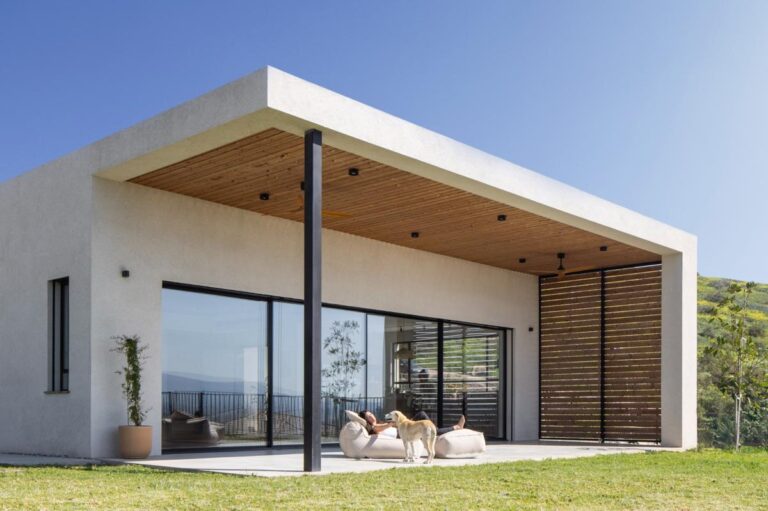 Exteriér domu využívá jednoduché geometrické tvary a velké prosklené plochy
