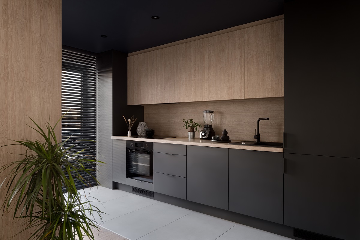 Moderní kuchyně v kombinaci světlého dřeva a tmavě šedých skříněk.