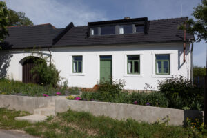 Dnešní podoba chalupy – pohled z ulice. Všimněte si nového vikýře, který přivádí světlo do podkroví, a zelenou barvou osvěžených dveře i rámů oken. Jako by tam vždy patřily!