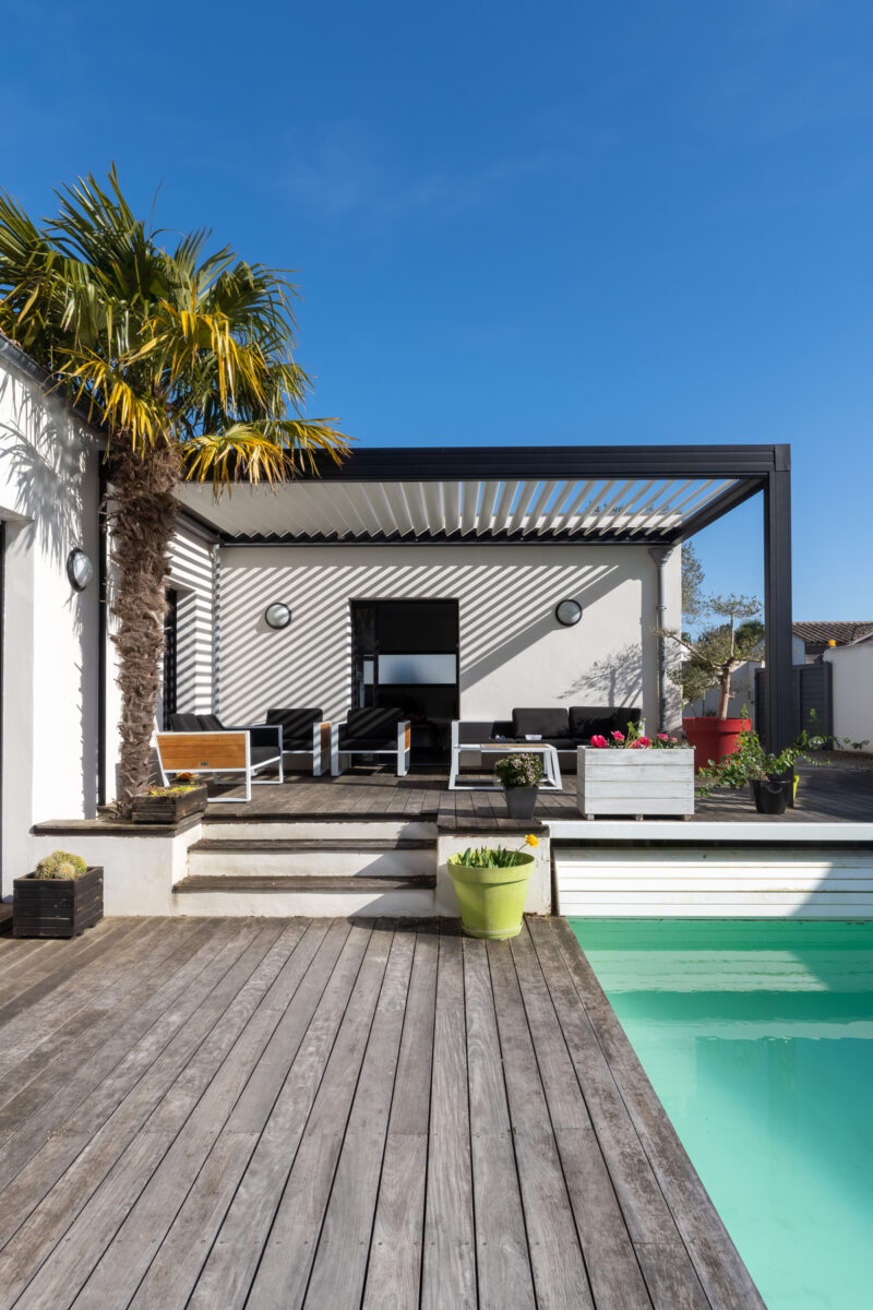 pergola stíní moderní terasu s bazénem
