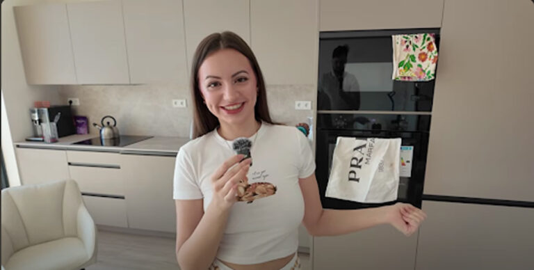 Moderní kuchyňská linka s vestavěnou troubou a ženou v bílém.