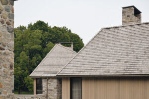 Detailní pohled na střechu a fasádu moderního domu z přírodních materiálů.