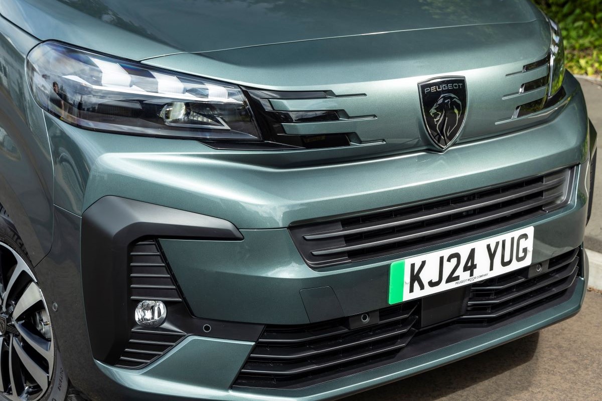 Detailní pohled na přední masku elektrické dodávky Peugeot e-Traveller s moderním designem a logem Peugeot.