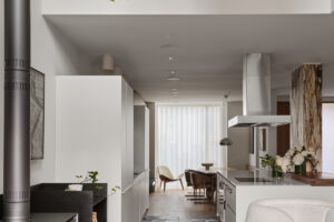 Moderní otevřená kuchyně propojená s obývacím pokojem, nadčasový design a kontrastní podlaha