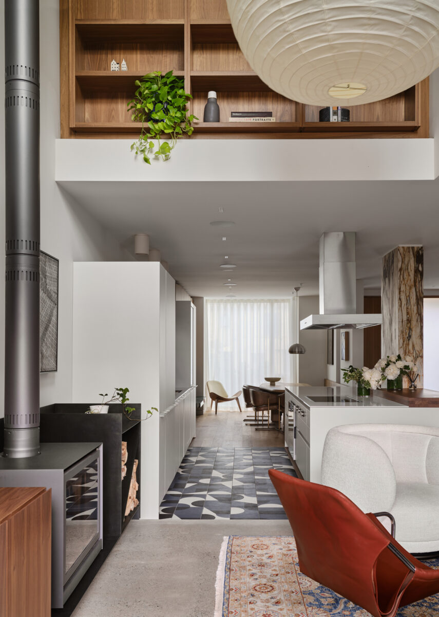 Moderní otevřená kuchyně propojená s obývacím pokojem, nadčasový design a kontrastní podlaha