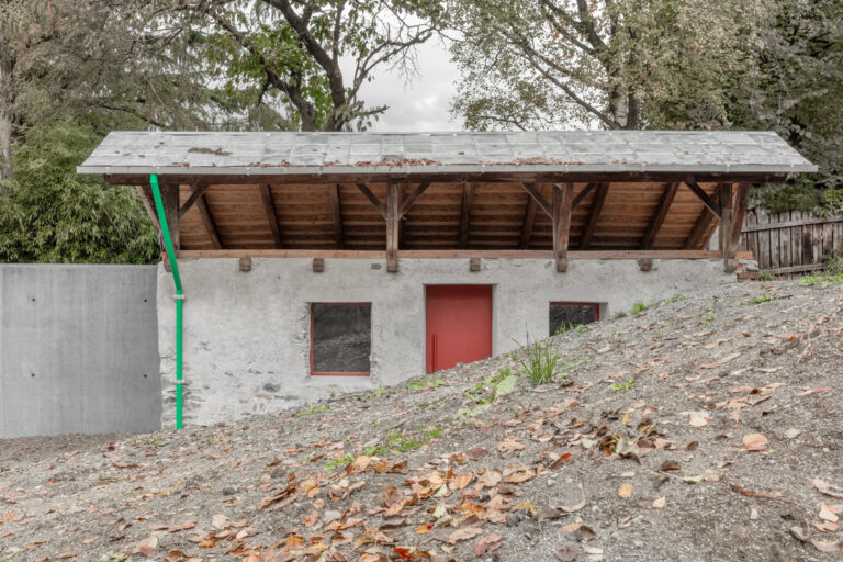 Malý kamenný domek obklopený spadaným listím, nově barevné prvky zvýrazňují jemnost architektonické obnovy.