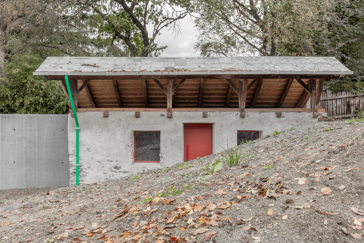 Malý kamenný domek obklopený spadaným listím, nově barevné prvky zvýrazňují jemnost architektonické obnovy.