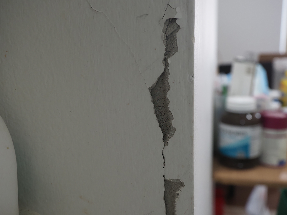 Detailní pohled na velkou prasklinu ve zdi – typická ukázka stavební závady, kterou lze při koupi nemovitosti přehlédnout.