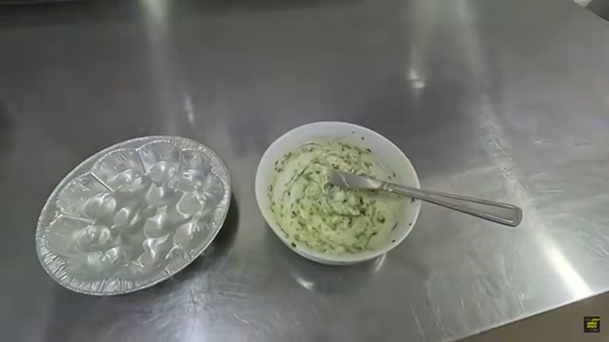 Domácí bylinkové máslo na šneky připravené k plnění lastur.