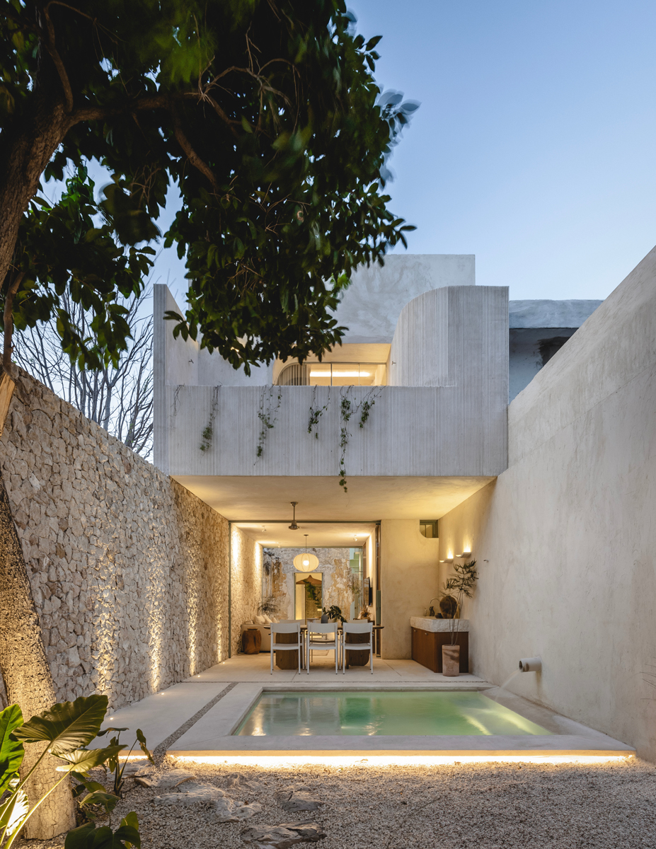 Moderní dvorek s malým bazénem, jídelním koutem a minimalistickou architekturou.