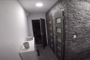Zrekonstruovaná předsíň se šedým obkladem a úložným prostorem.