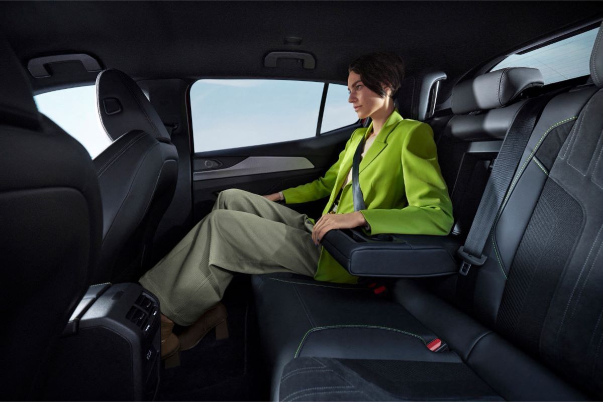 Žena sedící na zadním sedadle stylového interiéru vozu Peugeot 408 s koženkovým čalouněním.