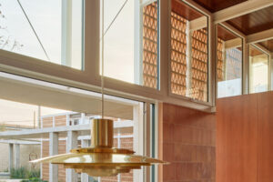 Detail jídelny ve středomořské vile s dřevěným stropem a designovým svítidlem