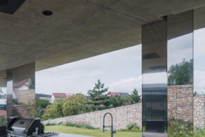 Moderní dům u Brna – venkovní kuchyně z nerezu s výhledem do zahrady.