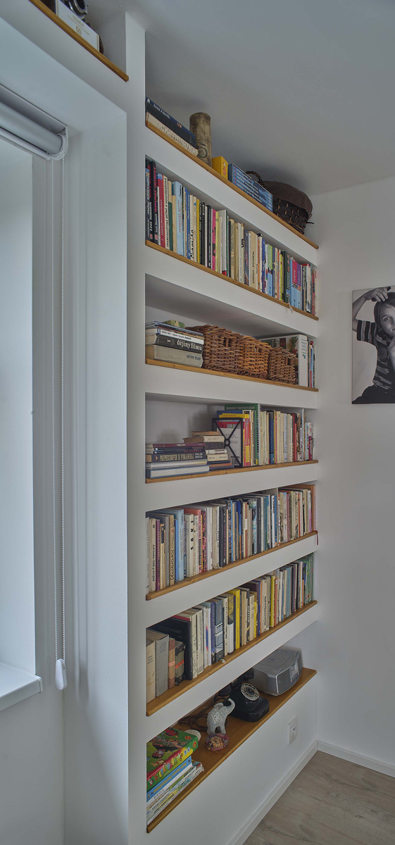 Vestavěná knihovna ze sádrokartonové příčky s policemi na knihy, vytvořená ze systému Habito H.