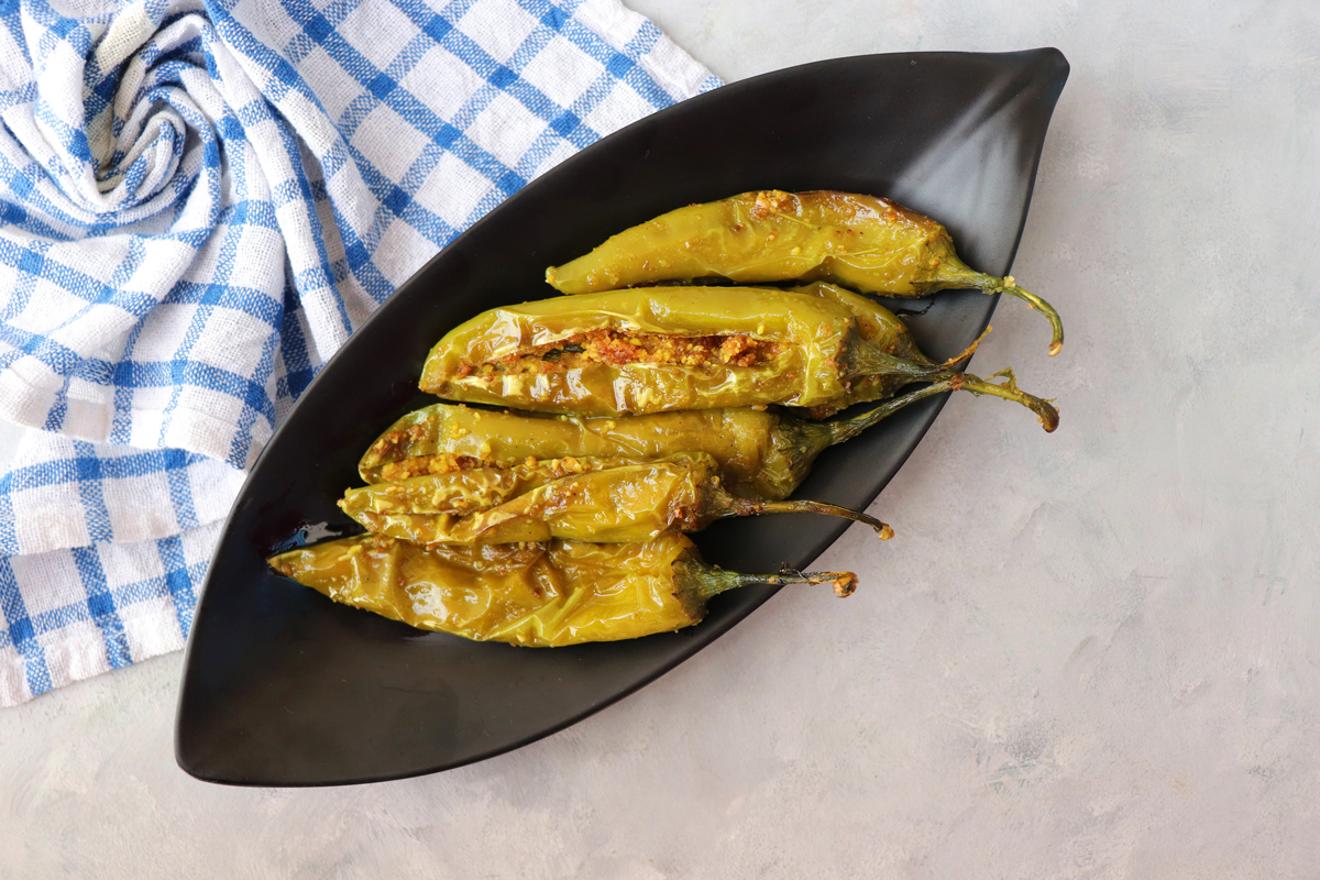 Tradiční indické zelené papriky Bharwa mirchi plněné kořeněnou směsí a zapečené.