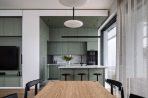 Designová jídelna s výhledem na moderní kuchyň a ostrůvek.