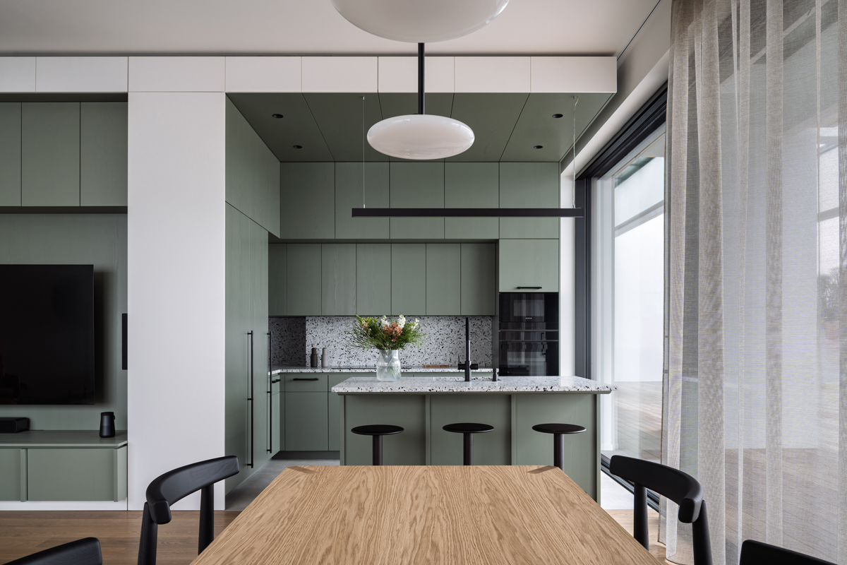 Designová jídelna s výhledem na moderní kuchyň a ostrůvek.