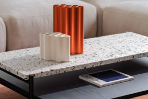 Terrazzo konferenční stolek s designovými vázami v moderním obývacím pokoji.