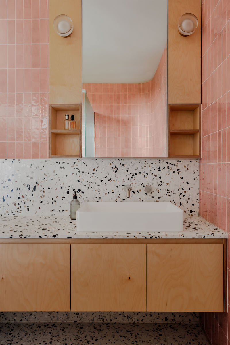 Koupelna s růžovými keramickými obklady a terrazzo deskou kombinuje svěžest a moderní eleganci.