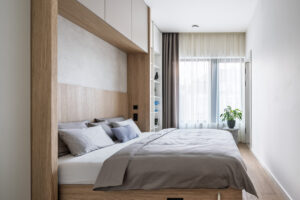 Moderní ložnice s vestavěným úložným prostorem a neutrální barevností.