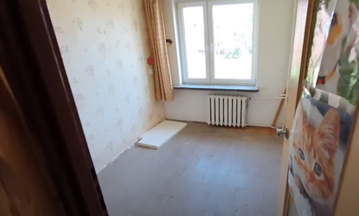 Pokoj před rekonstrukcí s retro tapetou a původním vybavením.