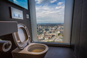 Moderní toaleta s panoramatickým výhledem na mrakodrapy a městskou krajinu.