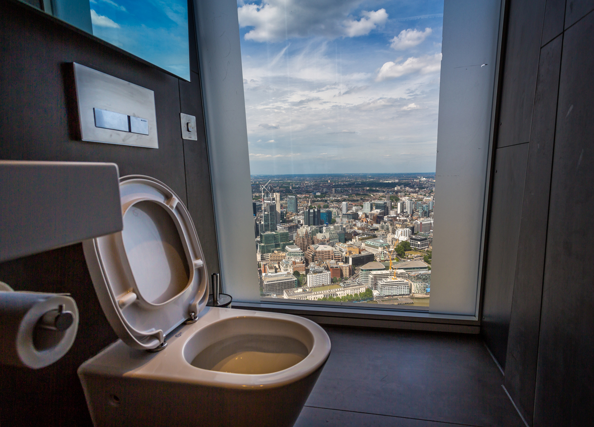 Moderní toaleta s panoramatickým výhledem na mrakodrapy a městskou krajinu.