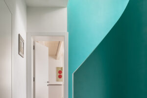 Vstupní chodba s výrazným modrozeleným schodištěm v rekonstruovaném domě v Křenovicích.