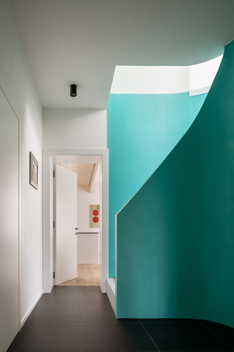 Vstupní chodba s výrazným modrozeleným schodištěm v rekonstruovaném domě v Křenovicích.