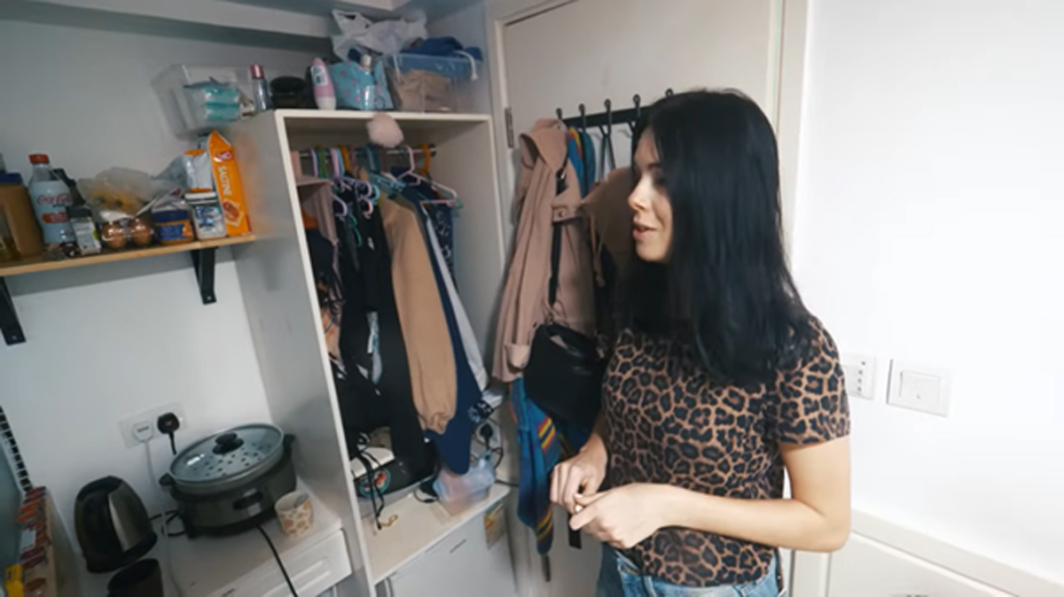 Kompaktní kuchyňský kout a šatní skříň v jednom prostoru miniaturního bytu.
