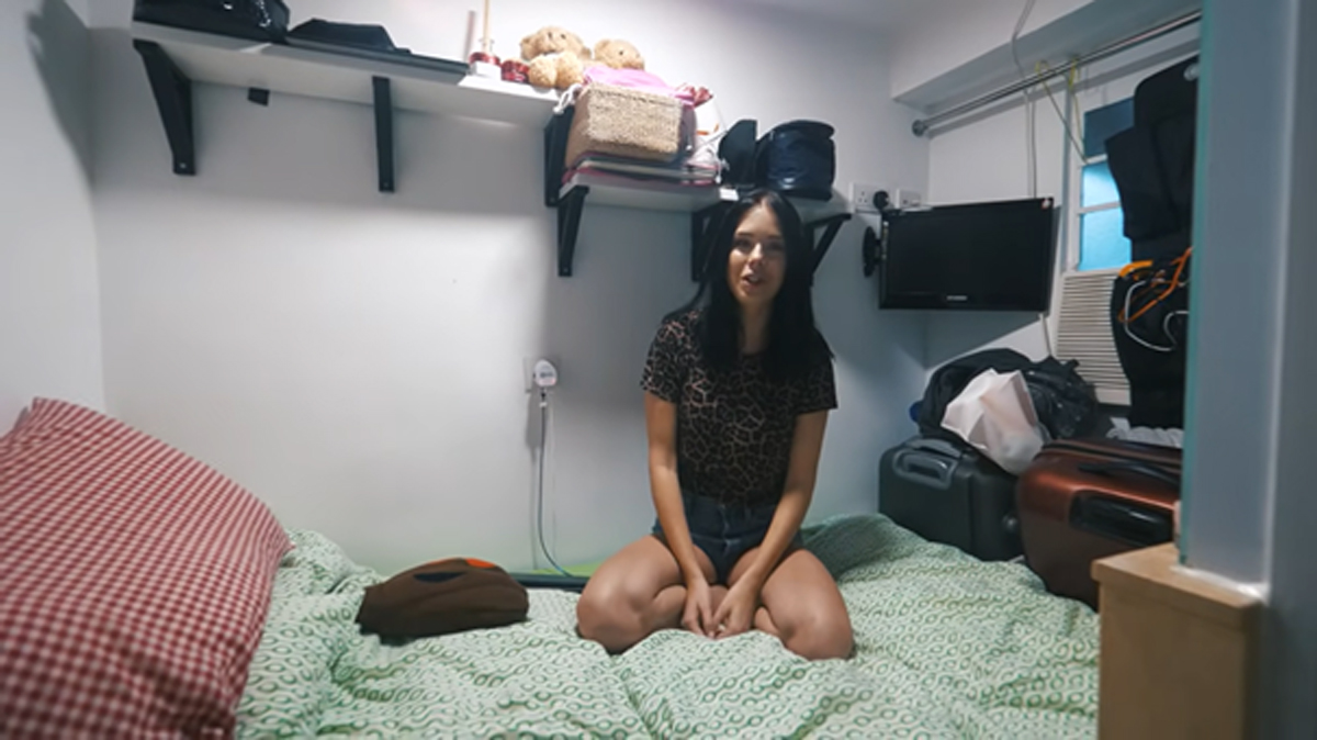 Útulný kout s postelí a drobnou televizí v malém bytě v Hongkongu.