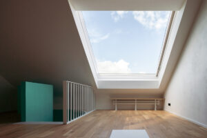 Světlé podkroví s velkým střešním oknem a dřevěnou podlahou v rekonstruovaném domě v Křenovicích.