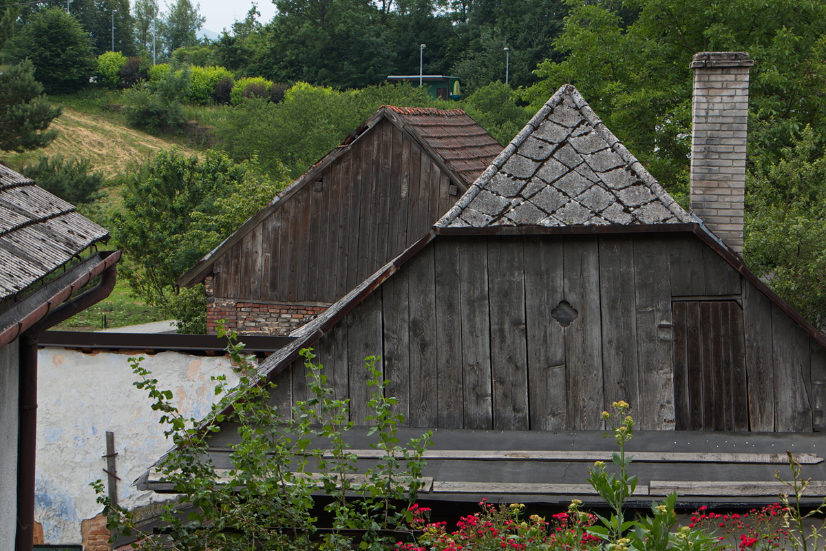 Pohled na staré dřevěné střechy a hospodářské budovy v historické části Štramberku.