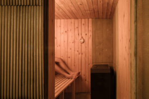 Interiér malé sauny obložený smrkovými deskami s tepelnou izolací z ovčí vlny a kamny.