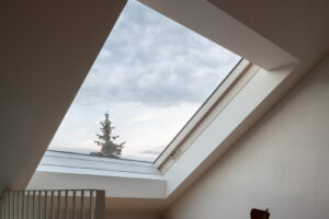 Interiér ateliéru s velkým střešním oknem a dřevěnou podlahou v rekonstruovaném domě v Křenovicích.