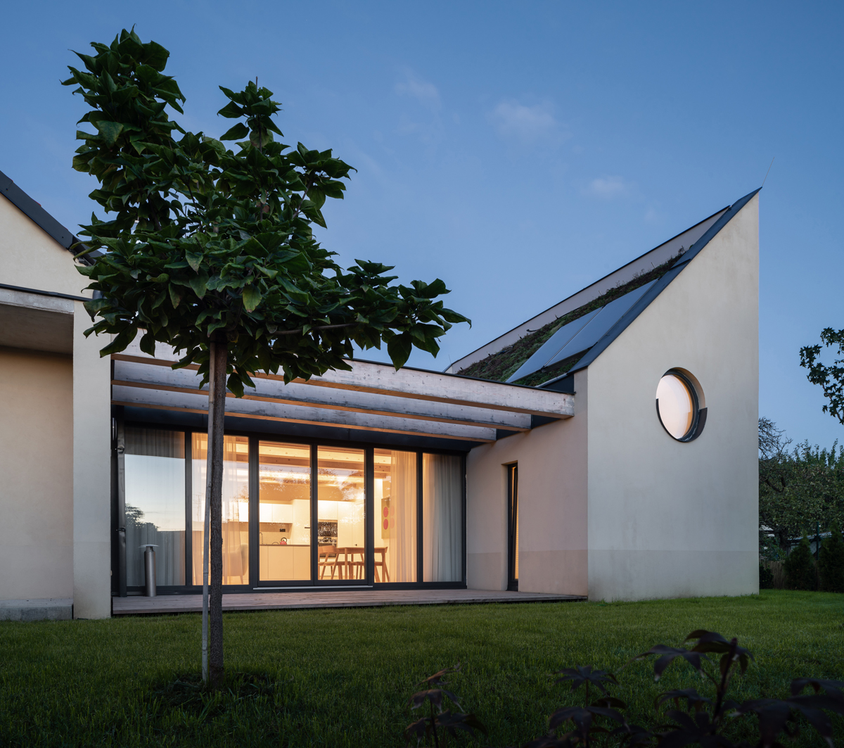 Moderní terasa se stíněním z dřevěných trámů a výhledem do zahrady u rodinného domu v Křenovicích.