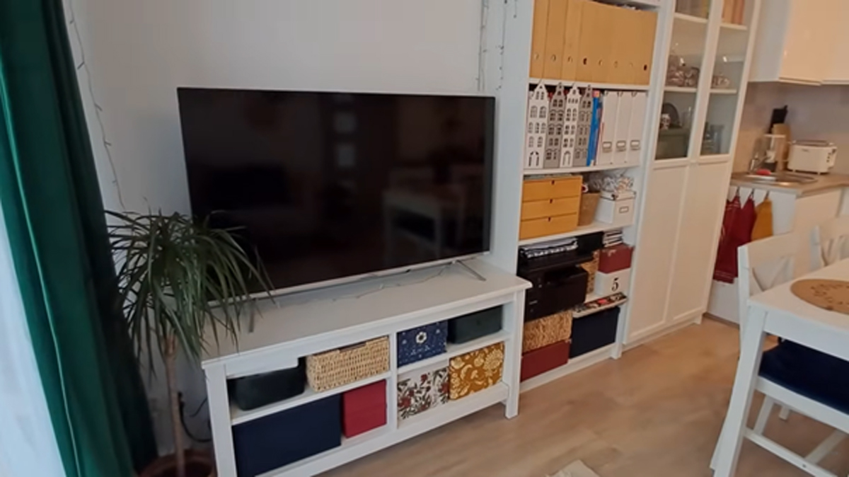 TV stěna s policemi, úložnými boxy a dekoracemi v moderním interiéru.