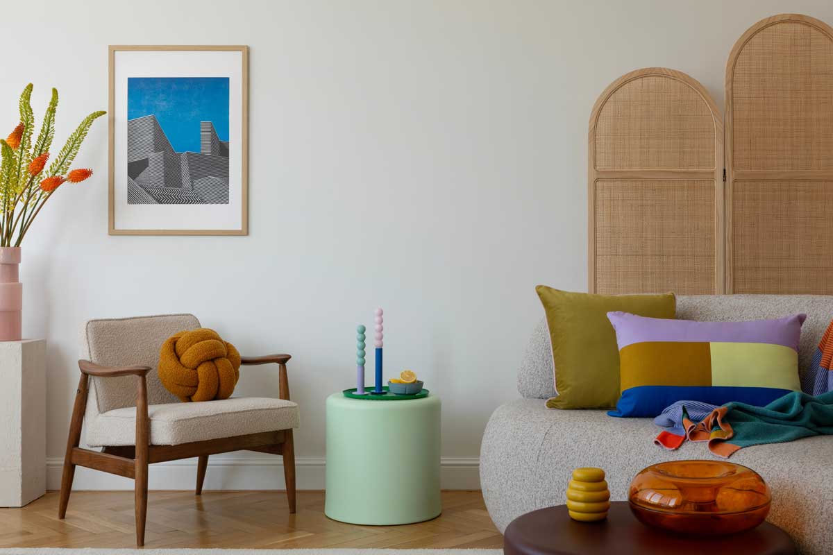 Barevný a osobitý interiér s designovými polštáři, uměním a dekoracemi, které ukazují styl obyvatele.