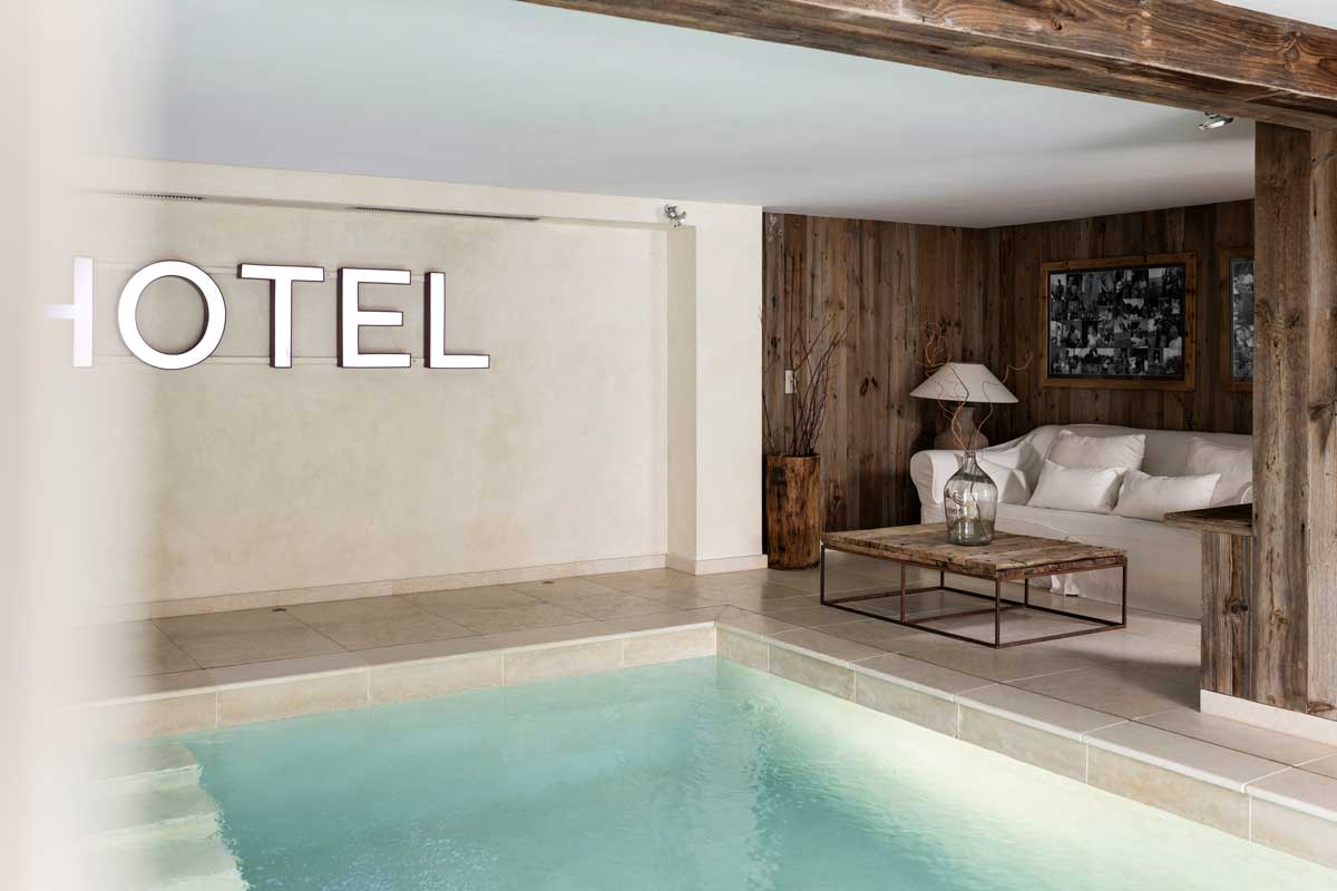 Místnost pro odpočinek vyzdobená recyklovaným dřevem, lněnými textiliemi a starožitnými detaily.