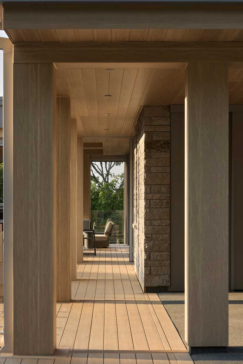 Dřevěná terasa plynule navazuje na interiér a slouží jako klidné místo pro pozorování světla a krajiny